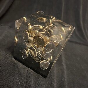 1971 penny lucite acrylic paperweight with a black base.